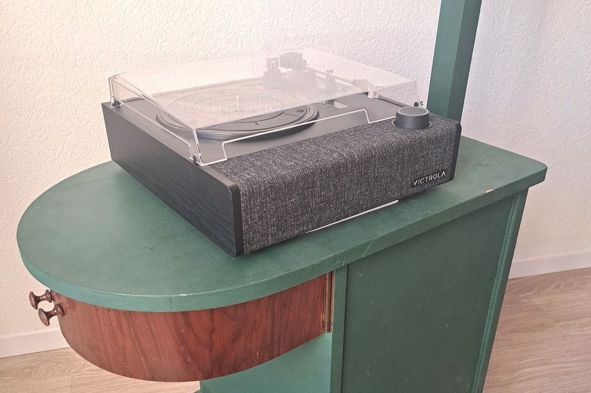 Platine vinyle posée sur un meuble vintage vert et bois