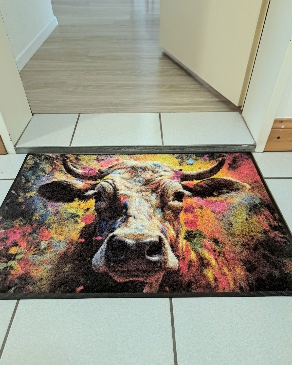 Paillasson coloré avec une vache à l'entrée de l'appartement